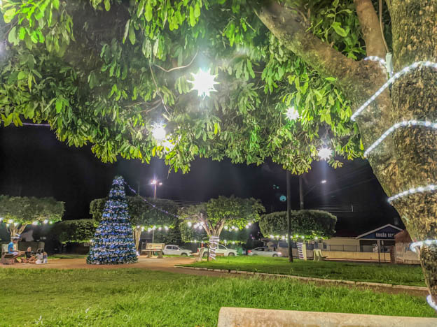  Foto da praça da rua Aderço Nunes da Silva, arvore de natal e adornos em coroa de flores iluminadas